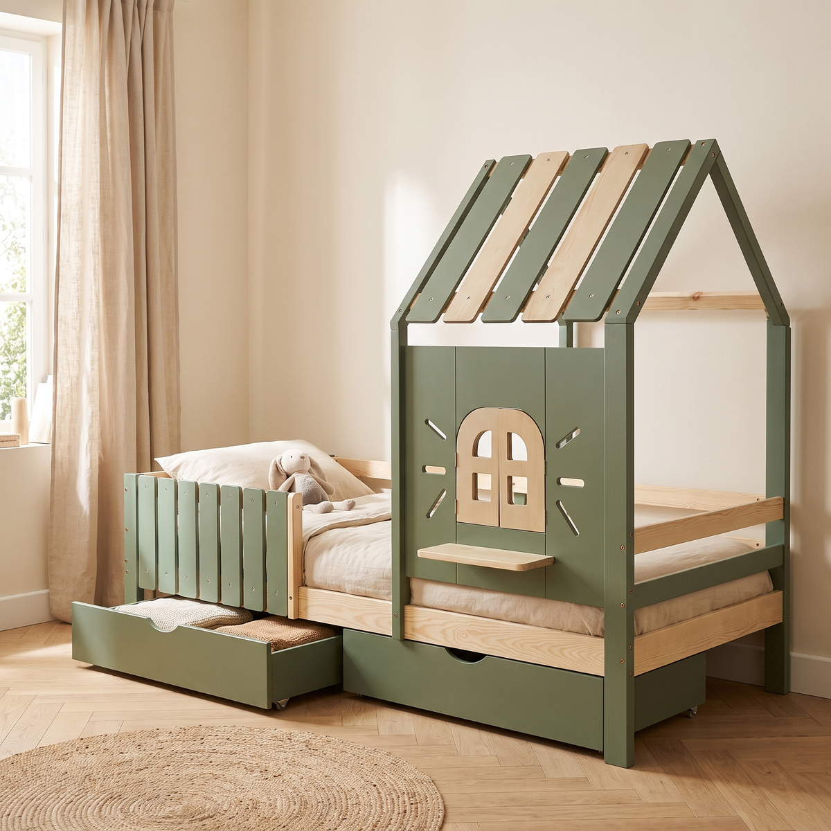 Lit cabane vert sauge avec fenêtre et tiroirs dans une chambre d'enfant